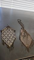 Pair of antique Mandalian mesh purses on a dark surface, showing overall condition and details.