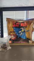 Classic Batman figurine in original packaging showing the box front and figurine inside with cape spread.