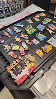 Wide view of Disney character magnets including Snow White, Seven Dwarfs, and other classic Disney figures laid flat on a black surface.