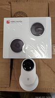 Sealed Family Pack 2-in-1 box containing two YI Home Cameras, with one extra YI Home Camera visible below the box.