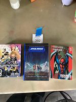 Three books placed side by side showing covers: Kingdom Hearts Volume 3 manga, Star Wars High Republic book, Spider-Man comic book.