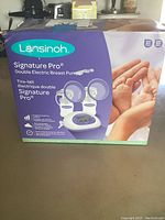 Front and side views of the Lansinoh Signature Pro double electric breast pump box showing product image and details.