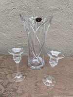 Photo showing Bohemia crystal vase and two matching crystal candle holders on a textured cloth surface against a plain background.