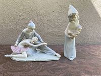 Photo showing ceramic dancers figurine featuring a clown and ballerina in stretching pose, delicately painted in pastel tones with no visible damage.