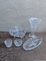 Full view of Webb Corbett crystal items: trumpet vase, pinwheel square bowl, creamer, sugar bowl, and oval dish.