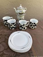 Full set showing 4 mugs, 4 plates, small teapot on warmer
