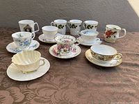 Front view of full lot including teacups with saucers and Christmas-themed mugs