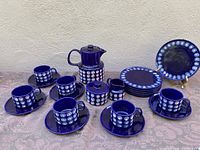Complete 21-piece tea set arranged on a table, showing teapot, cream, sugar, 6 cups and saucers, 6 tea plates in cobalt blue ceramic with white dotted pattern.