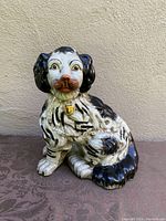 Front view of porcelain dog figurine showing detailed face, coloration, and collar.