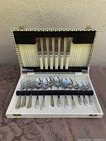 Complete vintage Bilchrome Sheffield cutlery set for 6 displayed in original box showing knives, forks, and spoons with white handles.