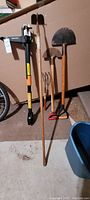 Full view of five garden tools including two hoes, two cultivators, and Fiskars extendable weeder
