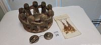 Photo showing entire lot: large brown carved friendship candle holder, two small metal clangers, and packaged accent charms