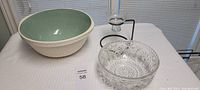 Overview of all three items on a table: large cream and green mixing bowl, crystal bowl, and glass/metal candle holder