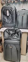 Four sage green Samsonite luggage pieces including two upright suitcases with wheels, smaller travel bag, and overnight bag