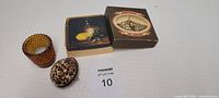Lot view showing amber dot glass votive candle holder, eggshell case, and coasters box