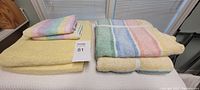 Stack of yellow and multicolor towels on table with seller lot number