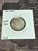 Reverse of 1930 Netherlands silver half gulden coin in white paper holder, showing crowned Dutch coat of arms and silver purity marking .720.