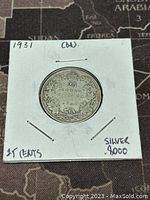 Front side of the 1931 Canadian 25 cents silver coin showing the denomination and maple leaf motif.