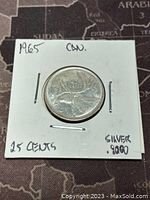Front side of the 1965 Canadian 25 cent silver coin in protective holder showing reverse with caribou.