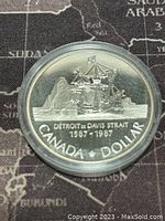 Obverse side showing the Detroit ship with the Rocky landscape and inscriptions 'DETROIT OF DAVIS STRAIT 1587-1987' and 'CANADA DOLLAR'.