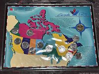 Full set of coins displayed on colorful map of Canada with all thirteen coins visible.