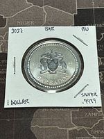 Obverse side of the 2022 Barbados silver coin showing coat of arms, year, and denomination.