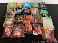Top view showing all 20 individually sealed McDonald's toys, with characters from Sonic, Ty Beanie Babies, and Nerf visible through packaging.