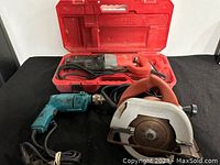 Three power tools including circular saw, reciprocating saw in case, and drill on a black surface.