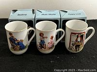 Three porcelain mugs displayed in front of their original boxes: 'Bedtime', 'Music Master', and 'Puppy Love'