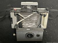 Front view of the camera folded out showing the lens, bellows, and controls