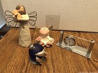 Group of assorted figurines including angel with dog, January angel, clock, and perfume bottle