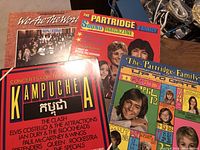 Four vintage vinyl albums including We Are The World, Concert for the People of Kampuchea, Partridge Family Up to Date and Sound Magazine, all with distinctive colorful covers.