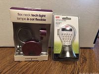 Photo of the flexible neck tech book light in package and the light bulb shaped calculator still in Staples retail packaging.