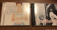 Two CD jewel cases, Celine Dion Falling Into You and Rumble Doll by Rachael Yamagata