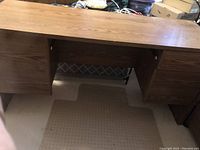 Full frontal view of the wooden credenza desk showing the left cupboard and right drawers with open leg space in the middle.
