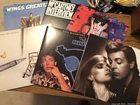 Photo showing seven vinyl record album covers arranged overlapping, featuring Paul McCartney, Wings, and related album titles.