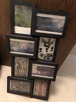 Nine black framed postcards featuring impressionist and Picasso artworks, including Monet's Water Lilies and Picasso's figures and still life paintings.