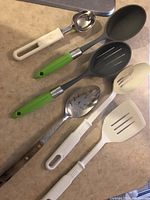 Six kitchen utensils including scoop, spatulas, and spoons with plastic and metal handles