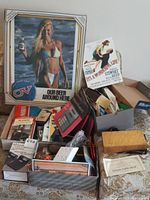Mixed box with magazines, books, books with spine visible, advertisements, and household supplies