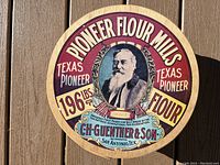 Close-up of the box lid showing colorful Pioneer Flour Mills vintage advertising, featuring text and a man's portrait.