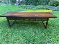 Full front view of rectangular coffee table on grass.