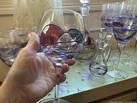 Close-up image of a large balloon glass showing the colorful stained glass leaf and swirl pattern