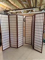 Pair of wooden frame room dividers with cream colored fabric panels, shown fully opened and standing upright.