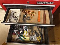 Top drawer showing drill grinding attachment, hex keys, calipers, and some hand tools like scissors and wire cutters.