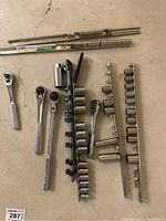 Full layout of socket wrenches, ratchets, socket holders, and extensions on floor.