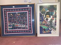 Two framed artworks side by side on carpet floor, showing the Hmong fabric panel on left in gold frame and the Chinese peasant painting on right in white frame.
