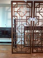 Two wooden lattice screen panels side by side against wall