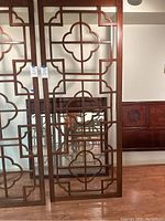 Full view of the two wooden screen panels standing side by side showing their size and pattern detail