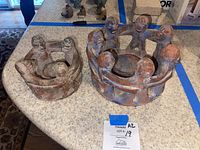 Two ceramic candle holders on a kitchen counter, one with four dancers and one with seven, showing rust and blue coloring