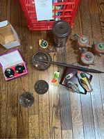 Overview of various Asian decor items arranged on wooden floor including tea pots, drinking cup, Ying-Yang music balls and wooden ducks